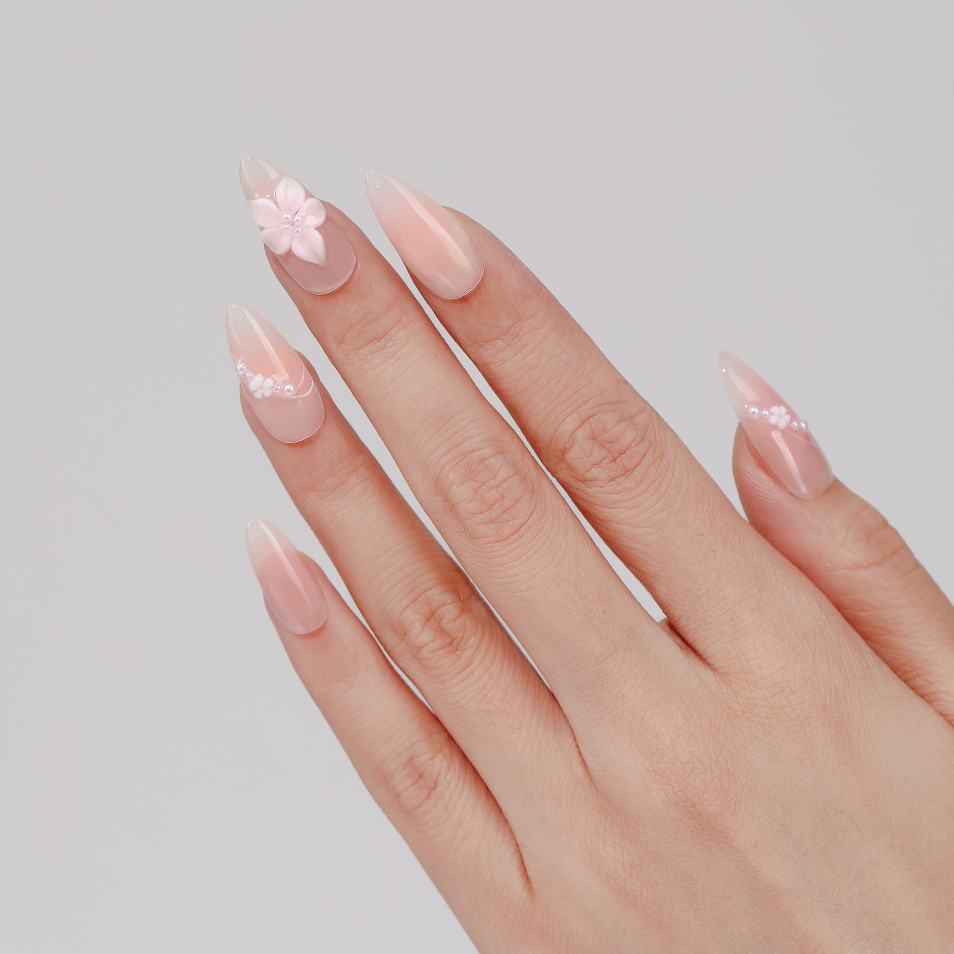 Blush Petal almond press-on nails worn on hand